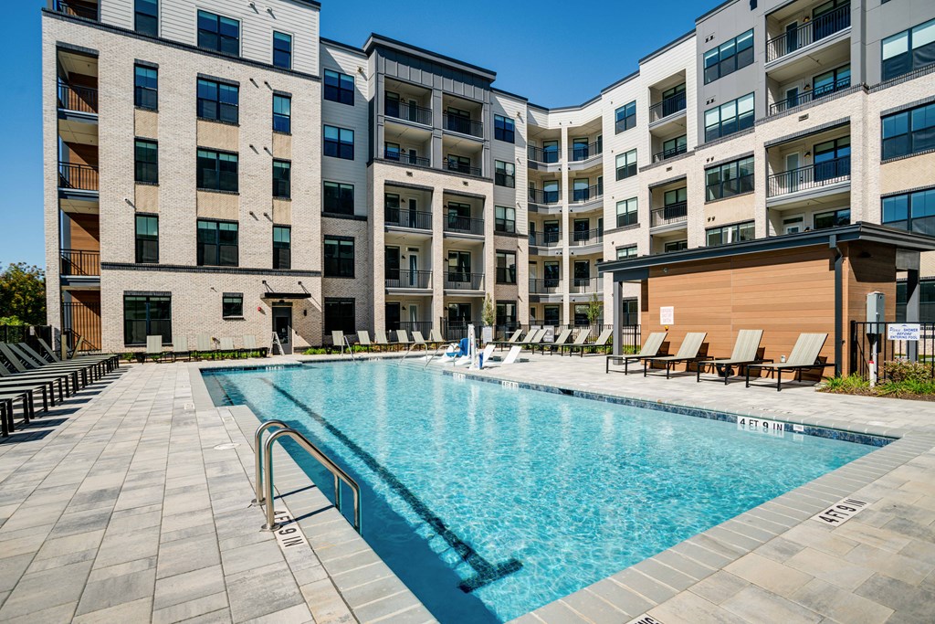 an apartment swimming pool in front of an apartment building