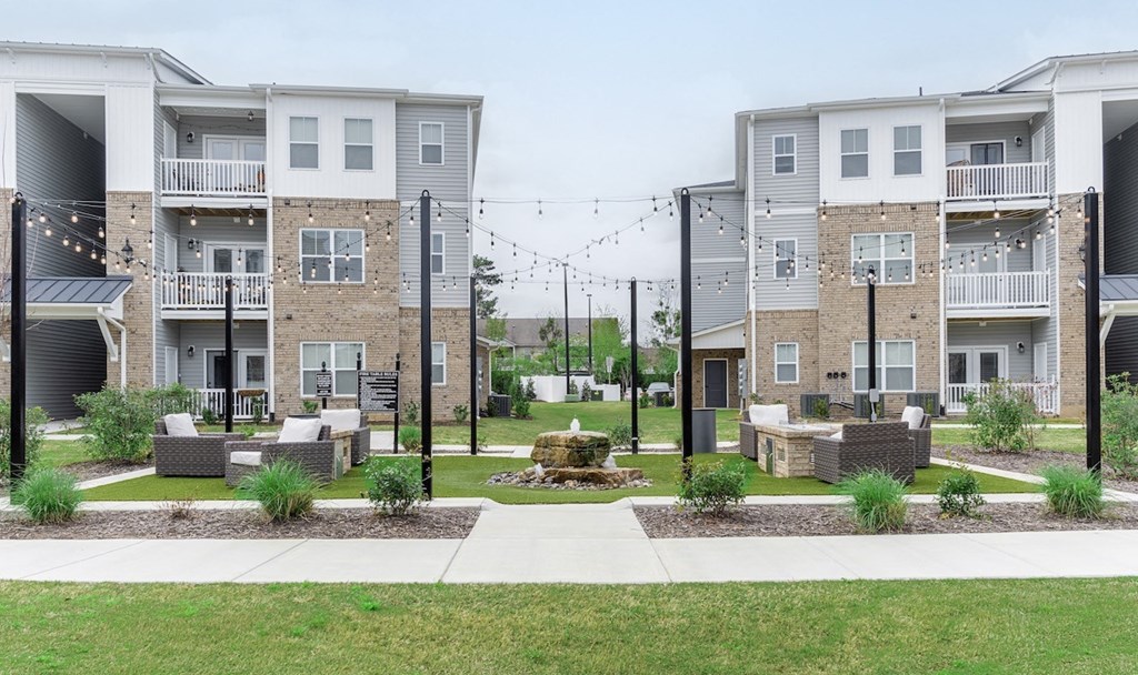 a courtyard with a fountain in the middle of an apartment complex