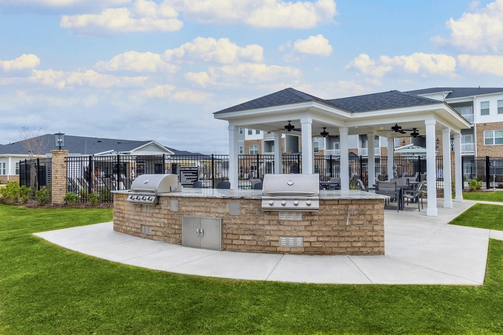 a covered patio with a grill and barbecue