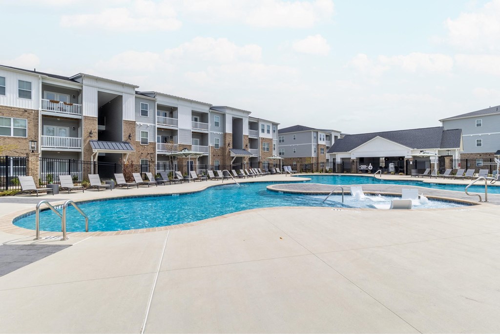 a large swimming pool with an apartment building in the background
