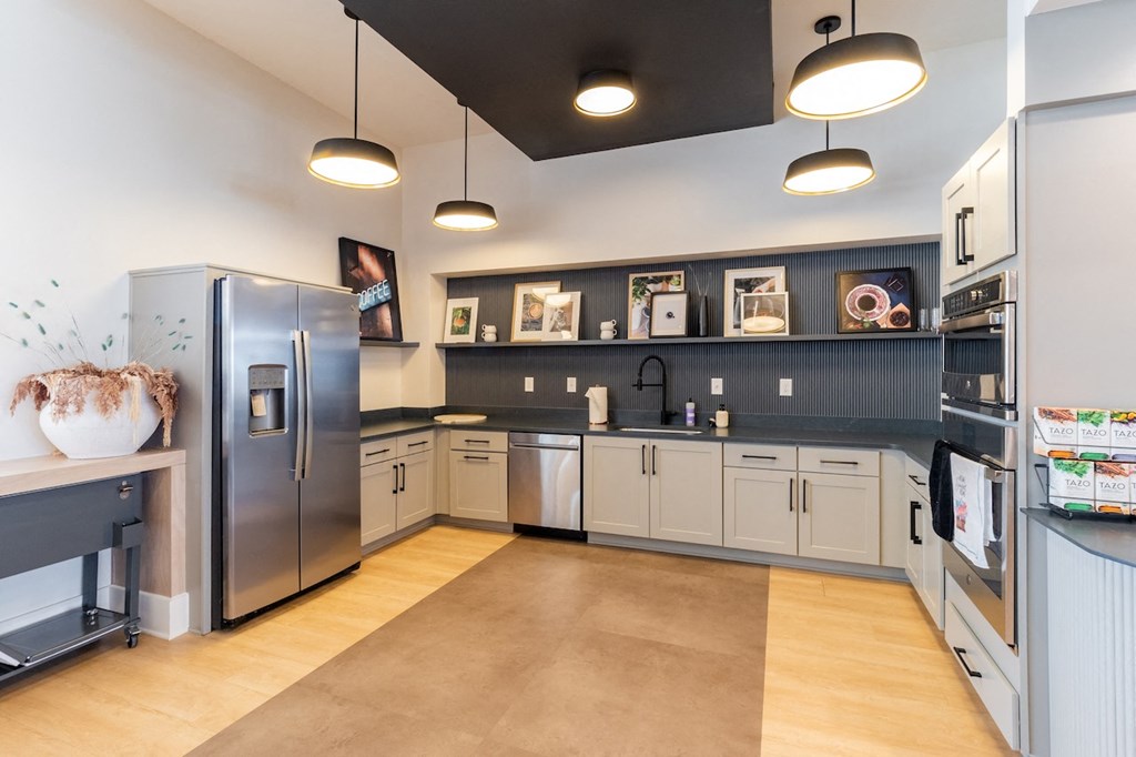 a kitchen with gray cabinets and stainless steel appliances