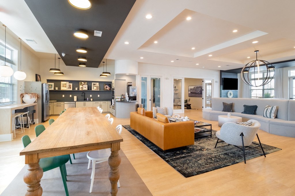 a living room and dining room with a large wooden table in the middle of the room