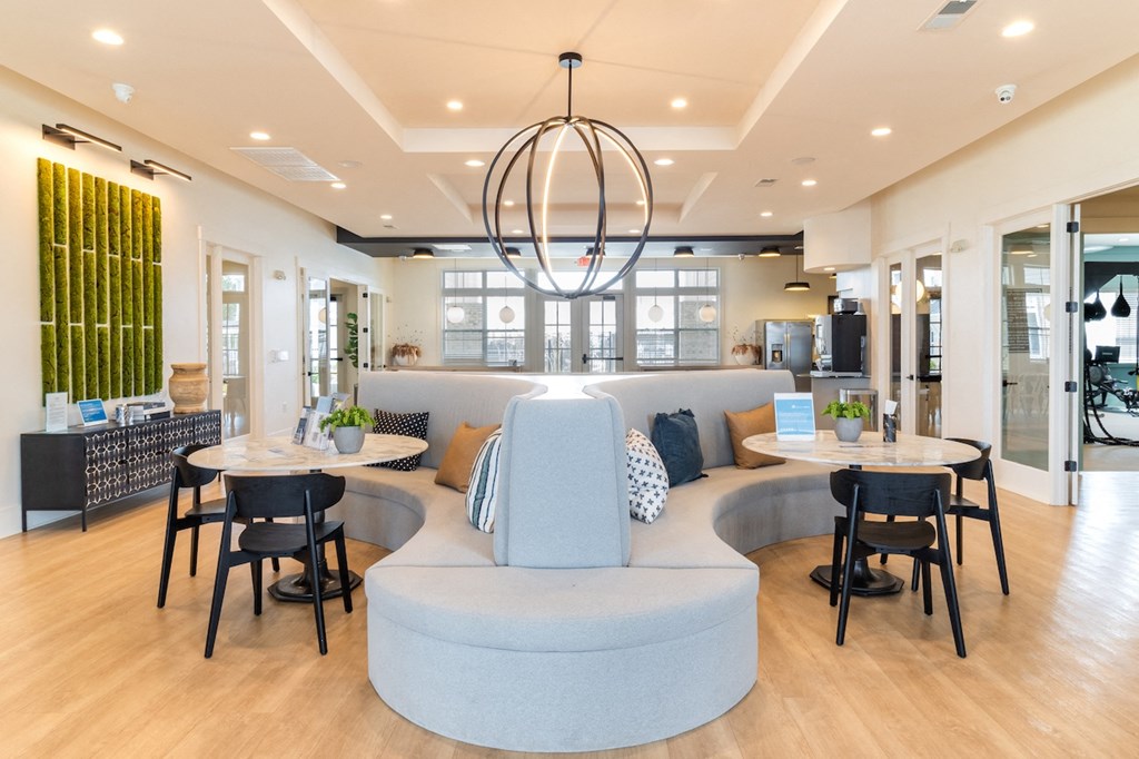 a resident clubhouse with two tables and a couch