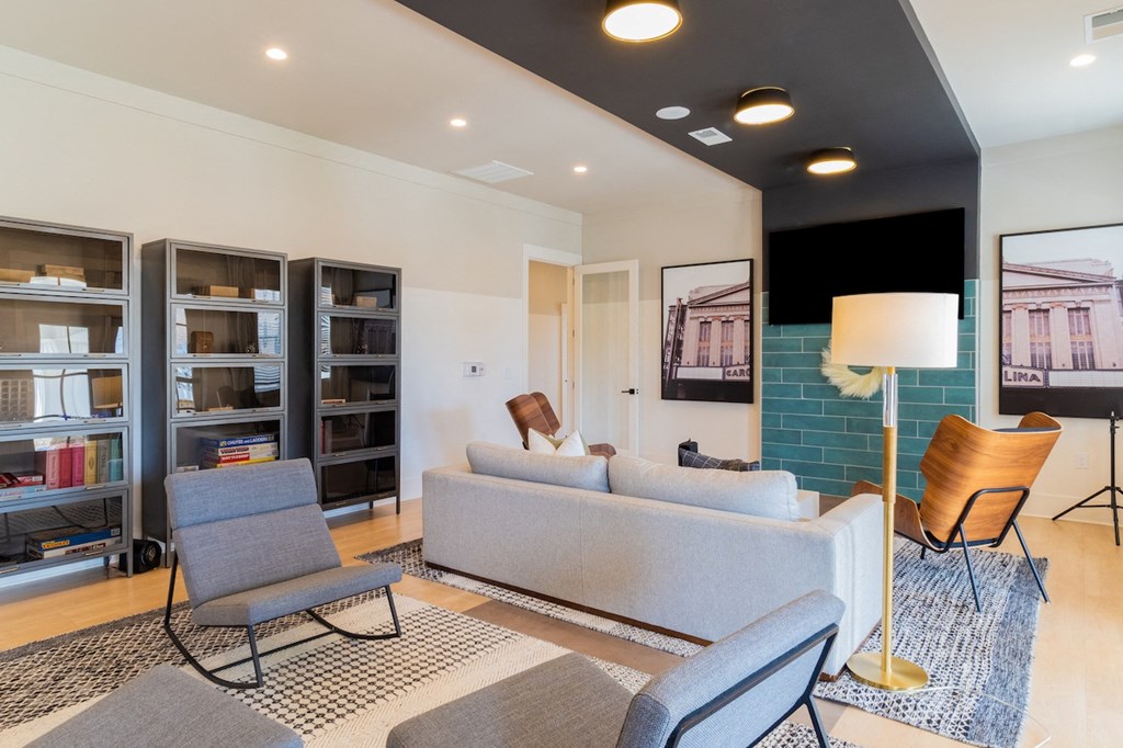 a living room with couches chairs and a bookshelf