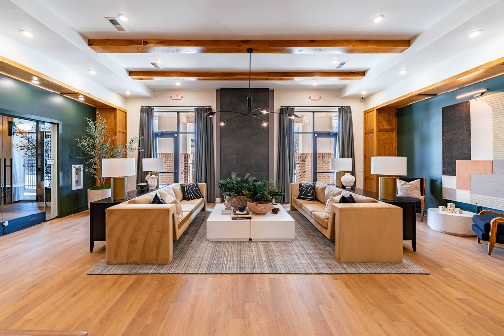 A modern living room with a large sofa set and a coffee table in the center.