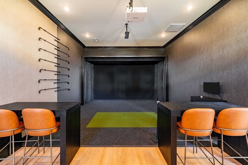 A room with a black table and orange chairs.