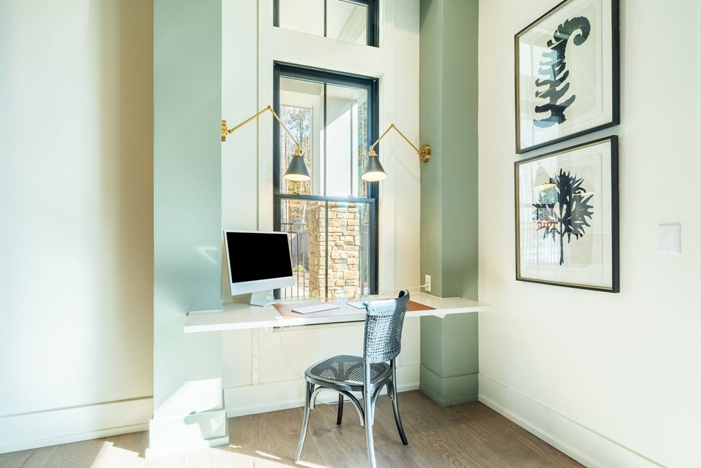 A desk with a computer and chair in a room.