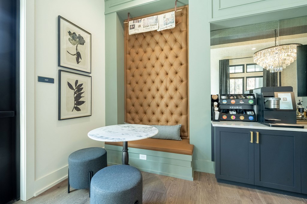 a business center with lounge seating and a coffee machine
