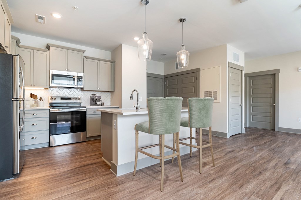 Spacious Kitchen Layout with Grey cabinets and Stainless Steel Appliances