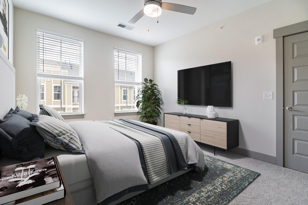 a bedroom with a bed and a tv on the wall