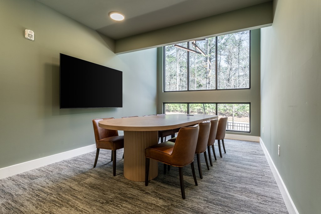 A conference room with a large table and chairs.