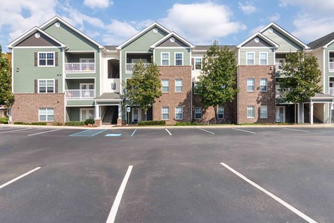 A parking lot in front of a row of apartment buildings at Hawthorne at the Hollow in Soddy Daisy, TN