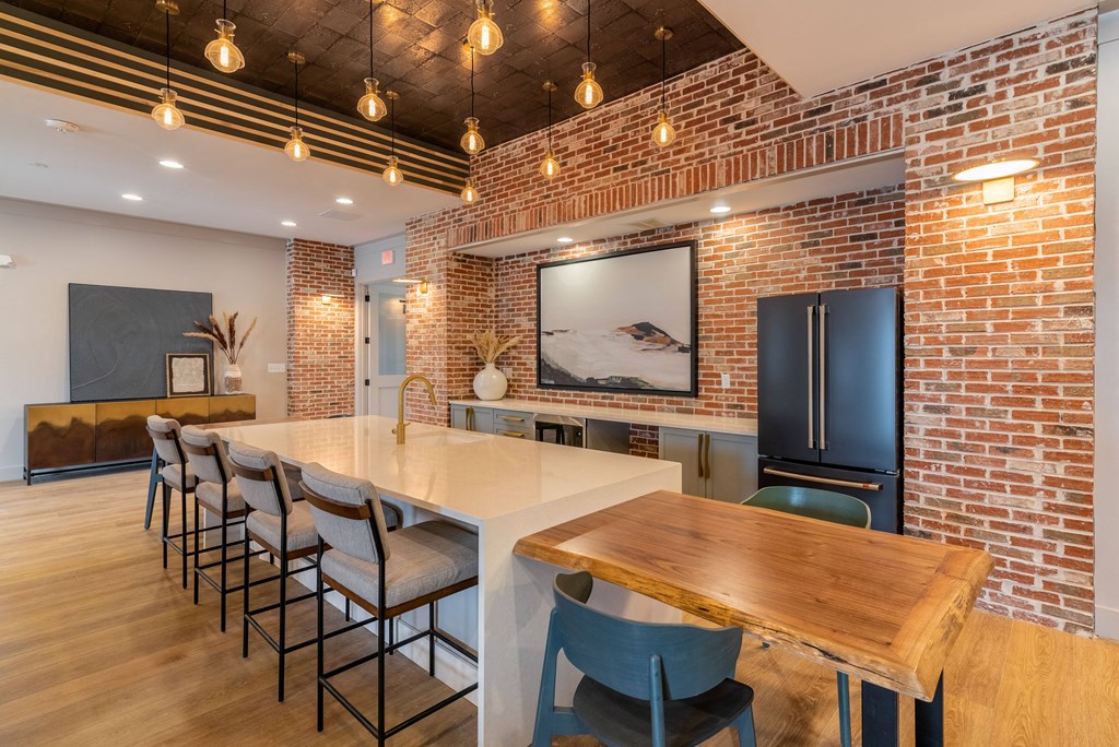 a dining room with a long table and chairs and a brick wall