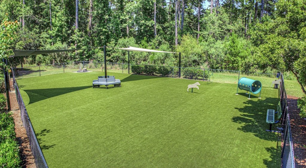 A green lawn with a white canopy and a black fence.