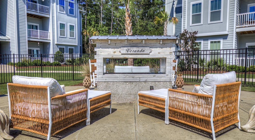 Two orange chairs are placed in front of a stone fireplace with the word "Villasana" written above it.