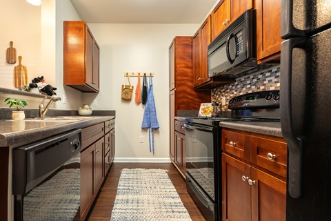 A kitchen with black appliances and wooden cabinets.