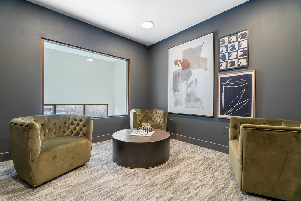 A modern office with a glass table and three chairs.