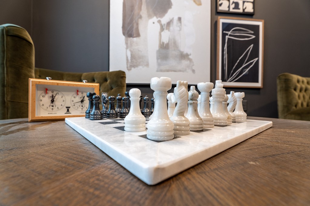 A chessboard with a black and white chess set on it.