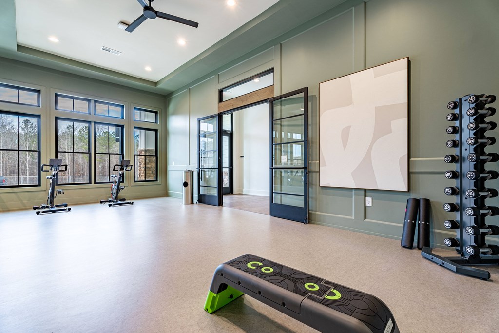 A room with a green and black treadmill in the foreground.