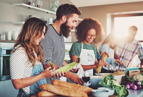 A group of people are preparing food together in a kitchen.