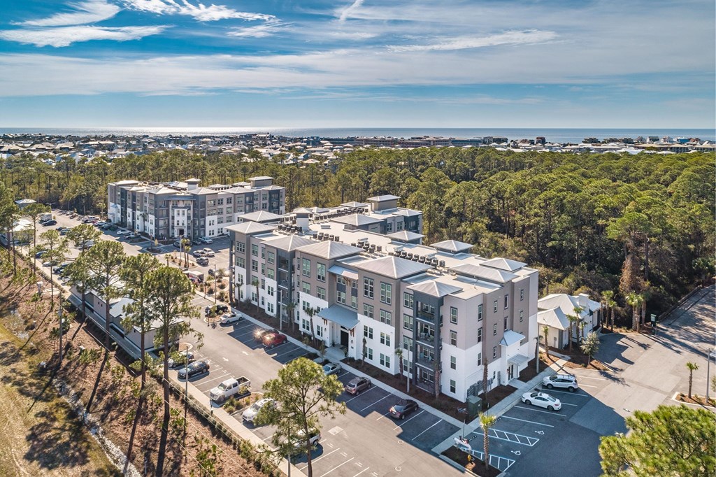 an aerial view of an apartment building overlooking the ocean