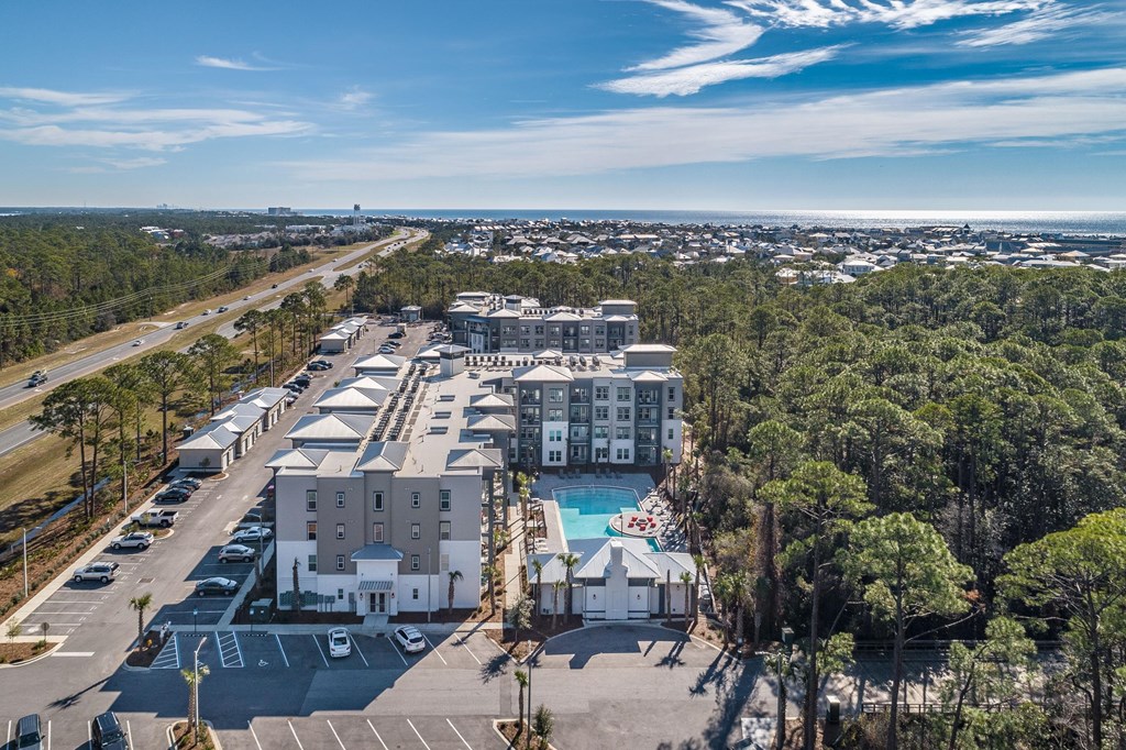an aerial view of a hotel with a swimming pool and a parking lot