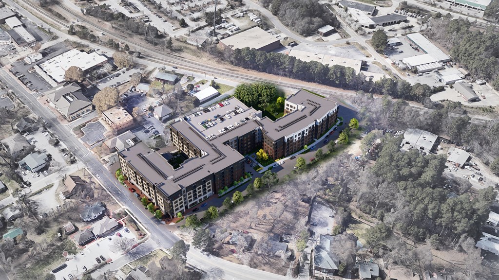 An aerial view of a large building complex surrounded by trees and other buildings.