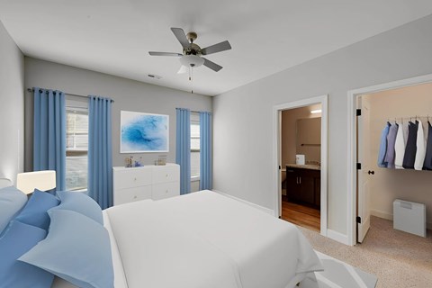 A bedroom with a white bed and blue curtains.