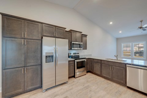 A kitchen with stainless steel appliances and wooden cabinets.