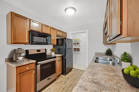 A kitchen with wooden cabinets and a granite countertop.
