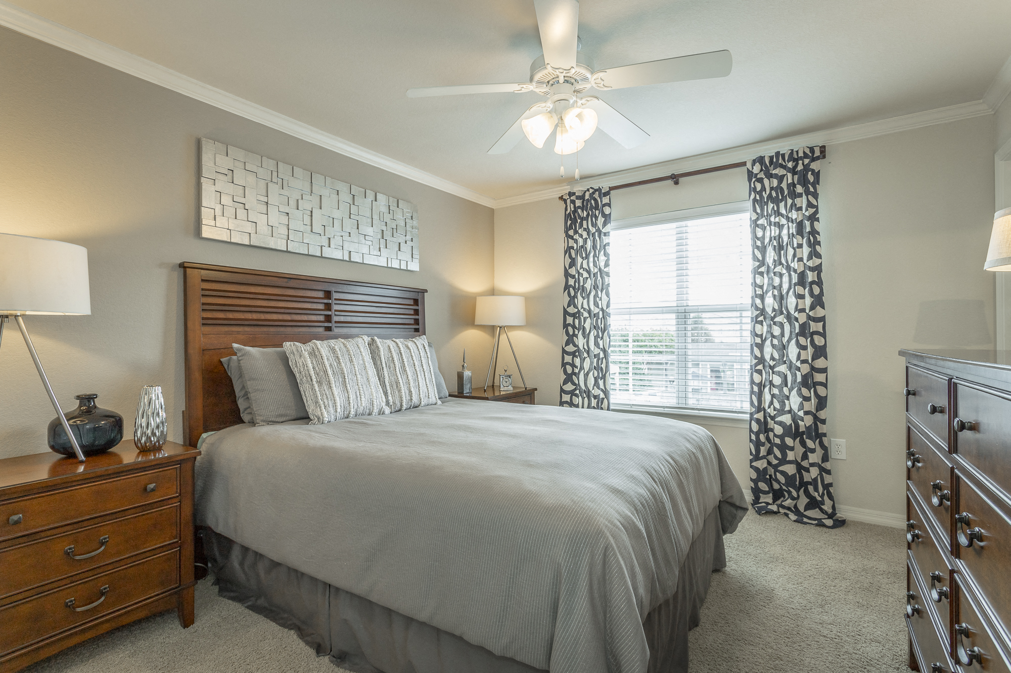 Beautiful bedroom at Amberleigh Ridge with plush carpeting, overhead lighting, designer ceiling fan and large windows