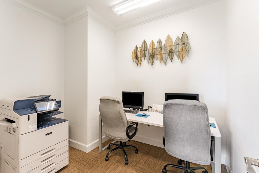a home office with two chairs and a desk with a computer and a printer