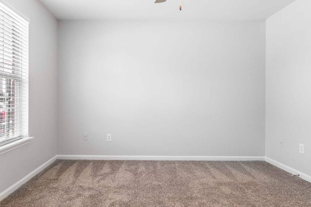 an empty room with carpet and a window