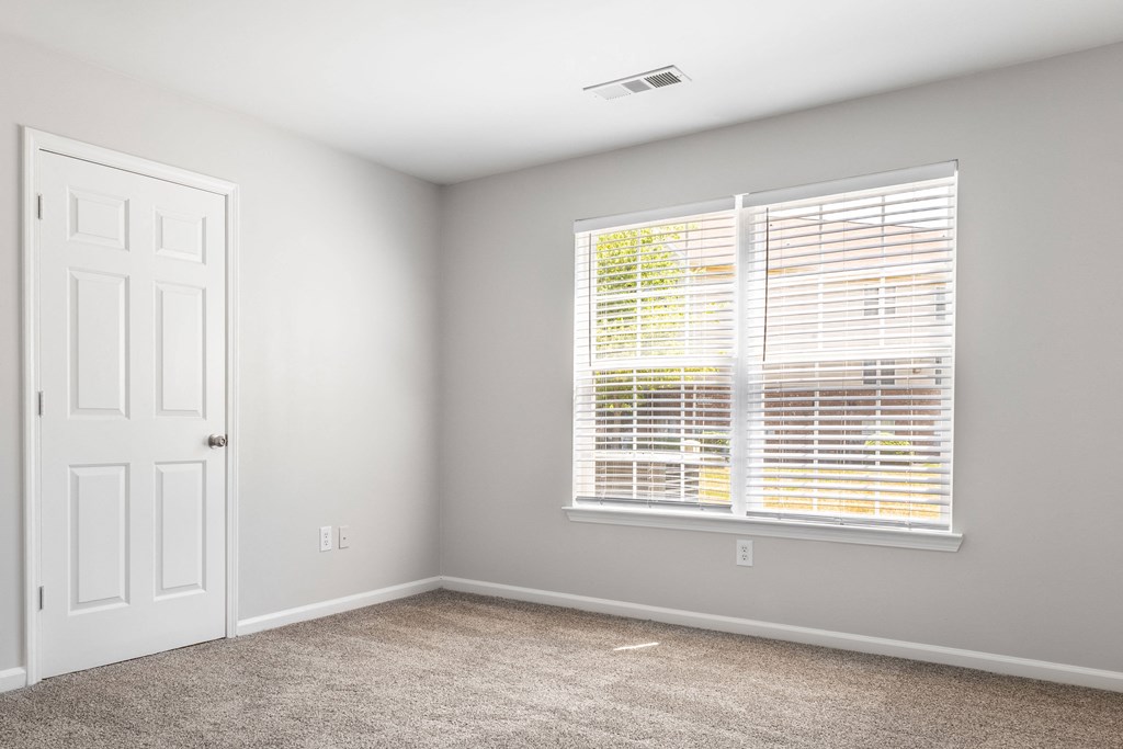 an empty room with a large window and a white door