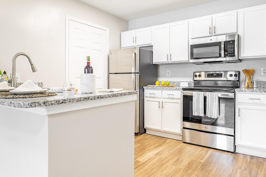 a kitchen with stainless steel appliances and white cabinets