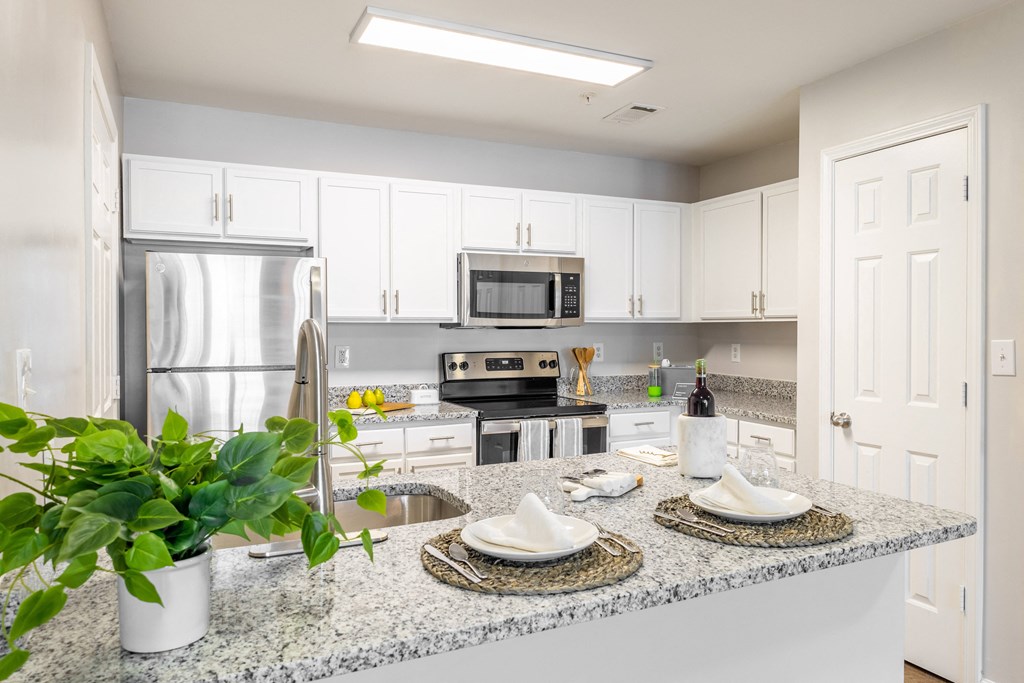 a kitchen with white cabinets and a granite counter top