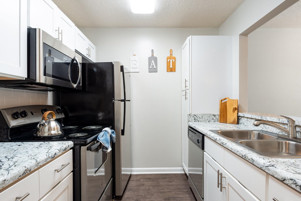 a kitchen with white cabinets and black appliances