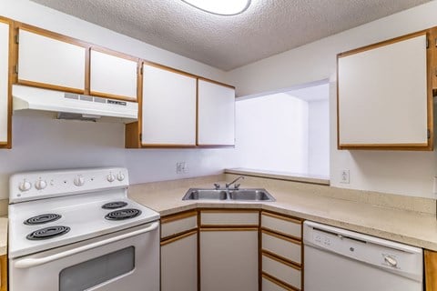 a kitchen with white appliances and a sink and stove