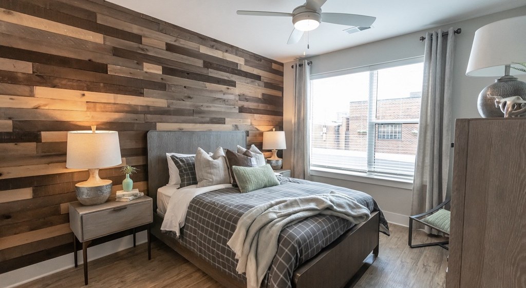 a bedroom with a bed and a wood accent wall