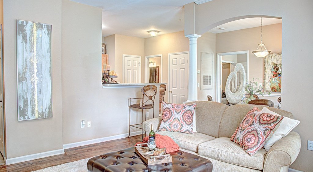 A living room with a couch, a coffee table, and a painting on the wall.