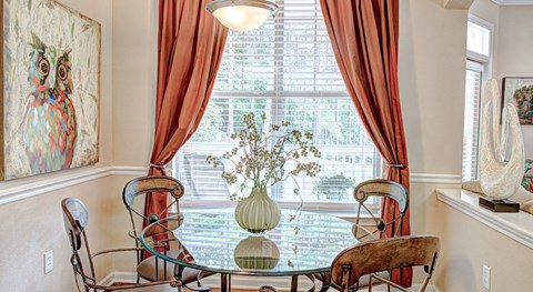 A dining room with a glass table and chairs.