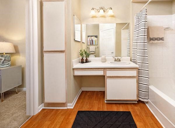 A bathroom with a white vanity and a striped shower curtain.