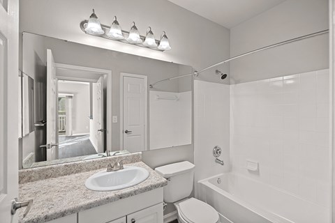 A white bathroom with a sink, toilet, and bathtub at Hawthorne Bridford in Greensboro, NC.