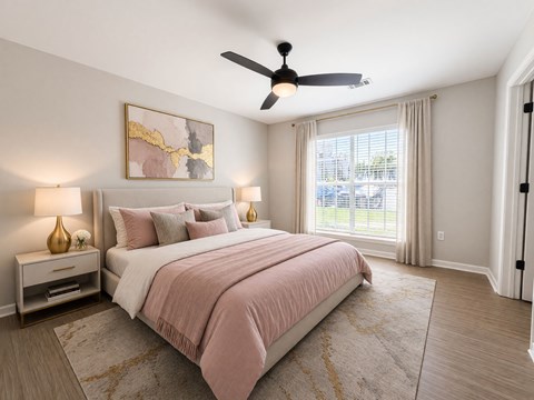 A bedroom with a bed, two lamps, and a painting on the wall.