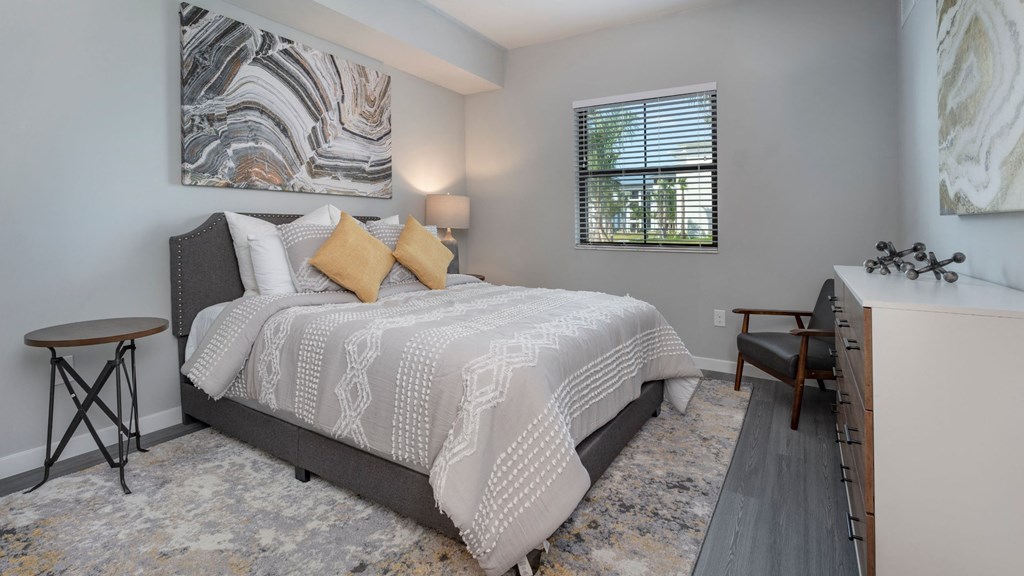 a bedroom with a bed and a desk and a window