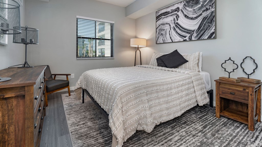 a bedroom with a bed and a desk and a window