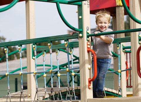 A young child is playing on a playground.
