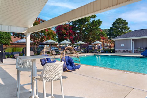 A pool area with a table and chairs.