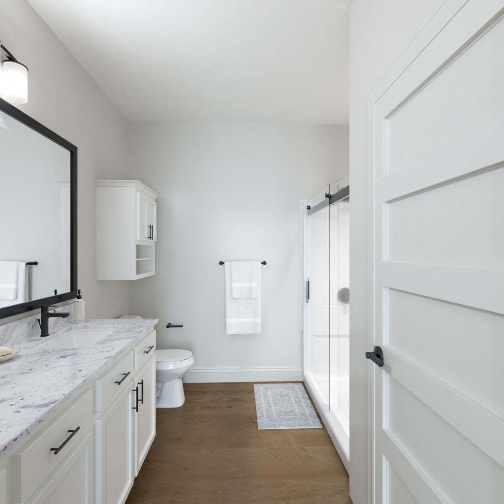 a bathroom with white cabinets and a white toilet and a sink