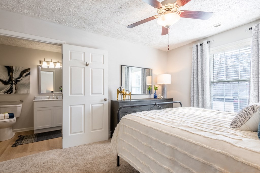 a bedroom with a bed and a ceiling fan